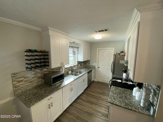 kitchen featuring decorative backsplash, sink, white cabinetry, and appliances with stainless steel finishes