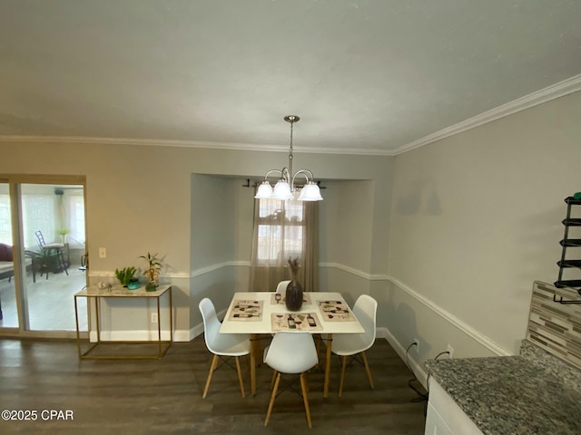 dining room featuring dark hardwood / wood-style flooring, ornamental molding, and a chandelier