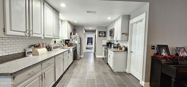 kitchen with light tile patterned floors, white cabinetry, appliances with stainless steel finishes, and tasteful backsplash