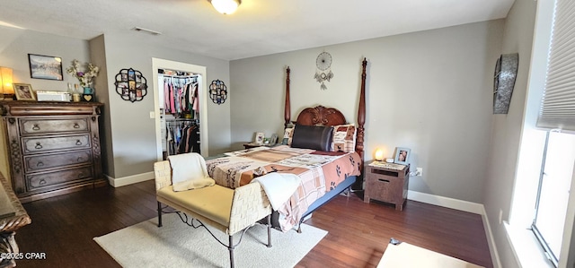 bedroom with dark hardwood / wood-style floors, a closet, and a spacious closet