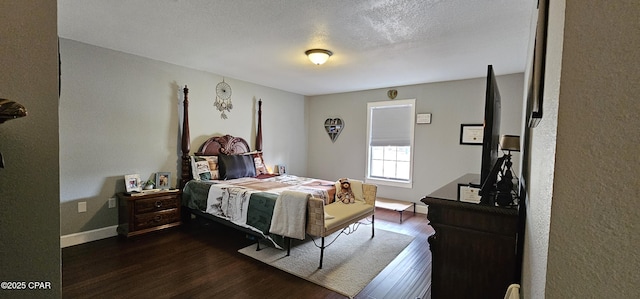 bedroom featuring dark wood-type flooring and a textured ceiling