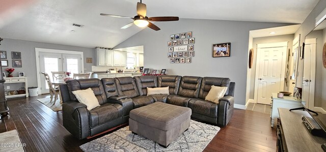 living room featuring ceiling fan, dark wood-type flooring, and vaulted ceiling