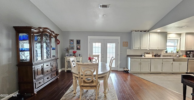 dining room with sink, a healthy amount of sunlight, lofted ceiling, and french doors