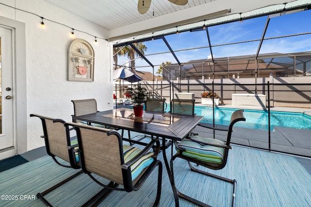 deck featuring a fenced in pool, ceiling fan, and glass enclosure