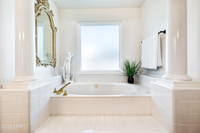 bathroom featuring tiled tub and ornate columns