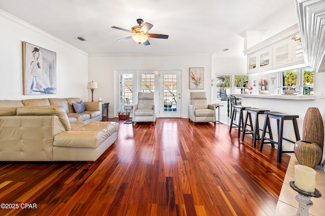 living room with dark hardwood / wood-style flooring, crown molding, and ceiling fan