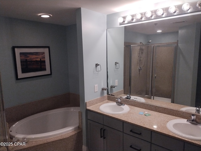 bathroom with a garden tub, a sink, a shower stall, and double vanity