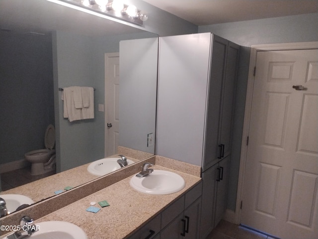 full bath featuring a sink, toilet, and double vanity