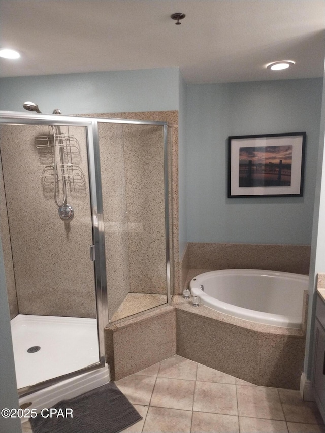 bathroom with a stall shower, a garden tub, vanity, and tile patterned floors