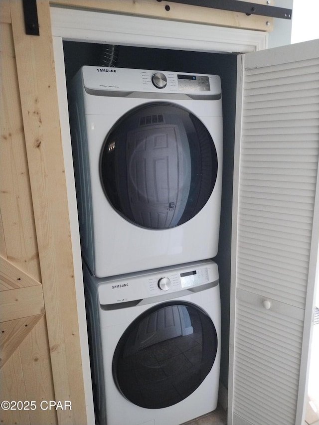 clothes washing area featuring laundry area and stacked washer / dryer