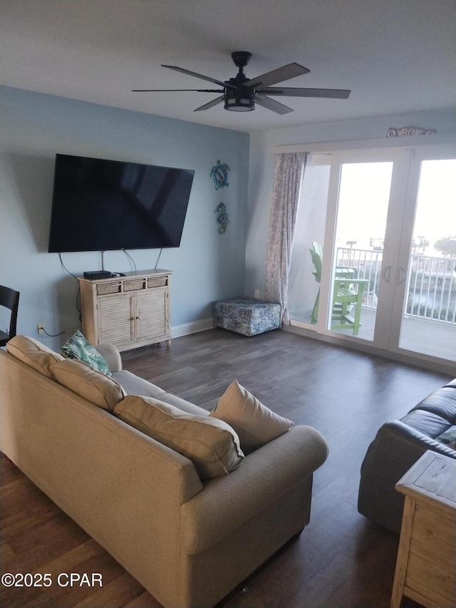 living area with baseboards, a ceiling fan, wood finished floors, and french doors