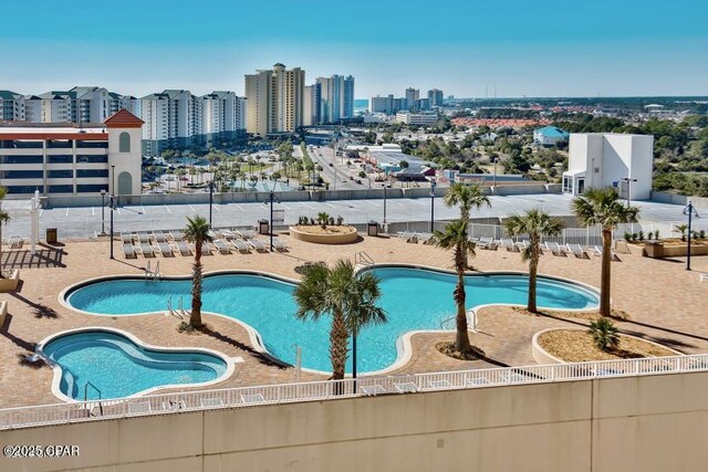 community pool featuring a view of city and a patio area