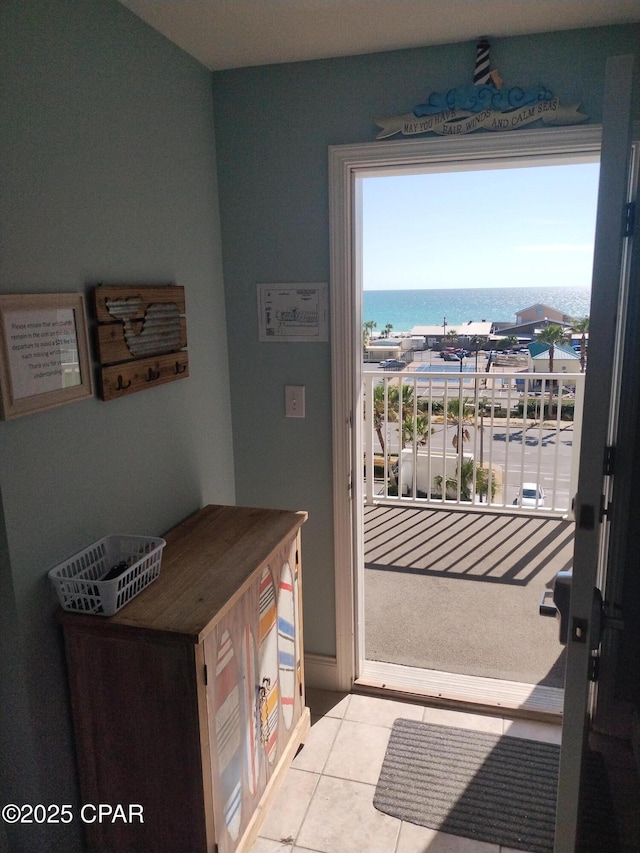 doorway featuring a water view and tile patterned flooring