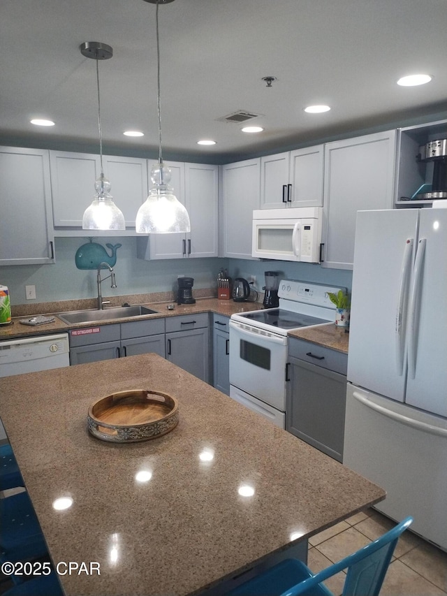 kitchen with light tile patterned floors, visible vents, hanging light fixtures, a sink, and white appliances