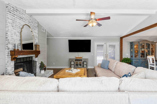 living room with hardwood / wood-style floors, vaulted ceiling with beams, ceiling fan, a brick fireplace, and french doors