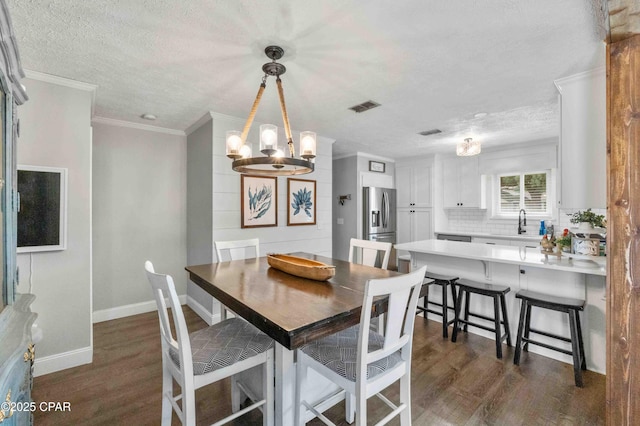 dining area with crown molding, dark hardwood / wood-style floors, an inviting chandelier, and a textured ceiling