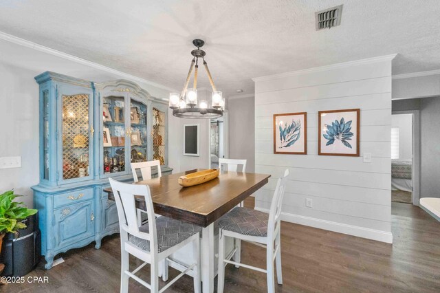 dining area with ornamental molding, dark hardwood / wood-style floors, a chandelier, and a textured ceiling