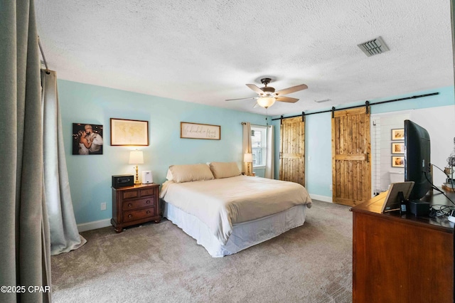 carpeted bedroom featuring a barn door, a textured ceiling, and ceiling fan