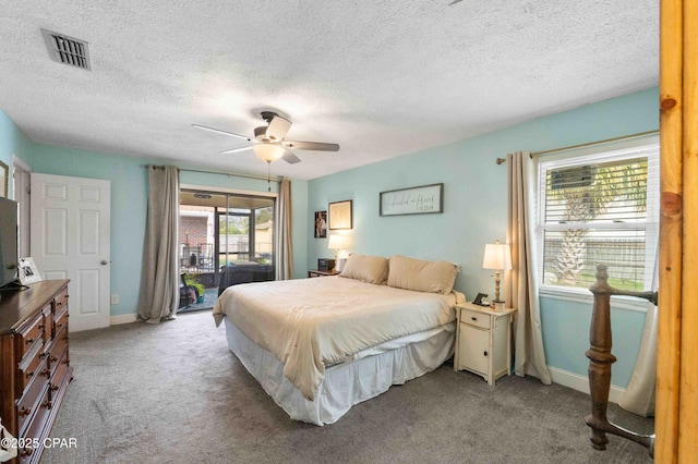 bedroom with ceiling fan, access to exterior, light carpet, and a textured ceiling