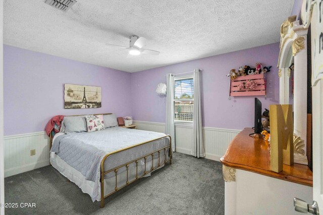 carpeted bedroom featuring a textured ceiling and ceiling fan