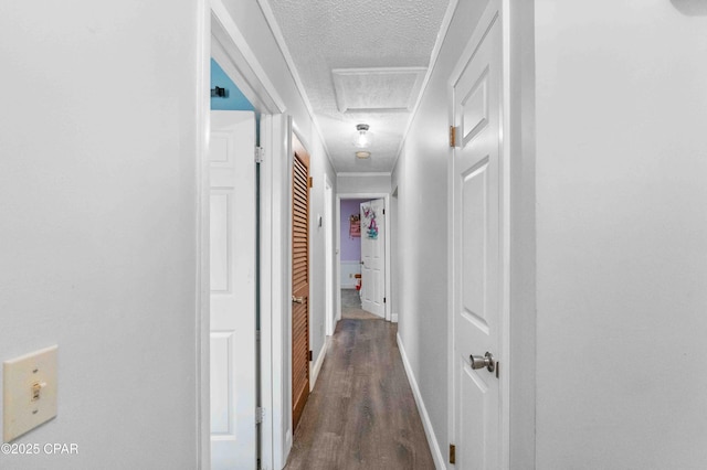 hallway featuring ornamental molding, dark hardwood / wood-style flooring, and a textured ceiling