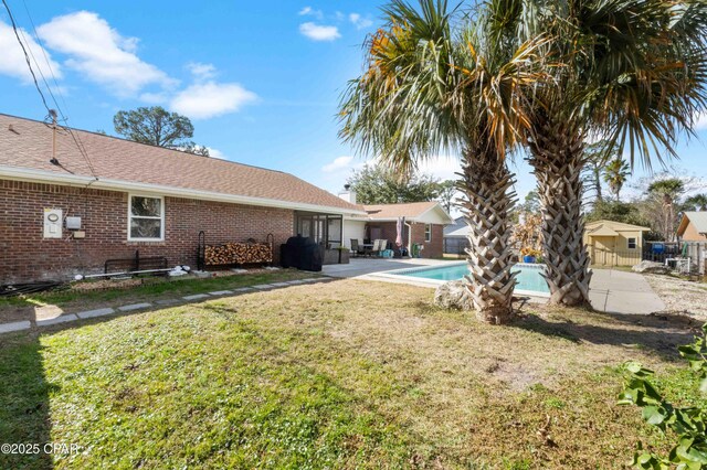 view of pool featuring a yard, a patio area, a sunroom, and central AC