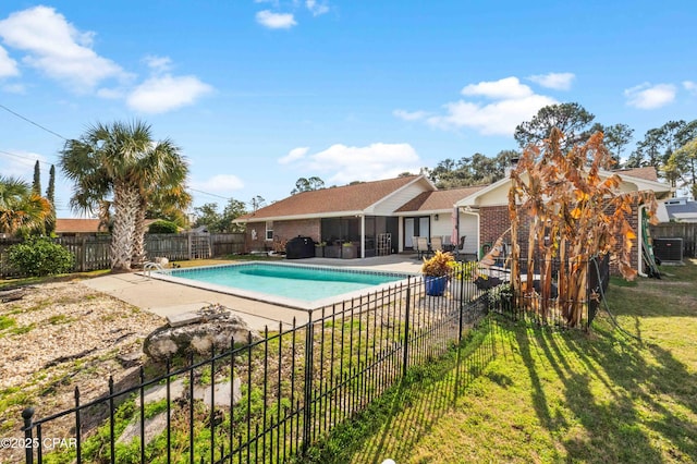 view of swimming pool with a patio, a sunroom, cooling unit, and a lawn