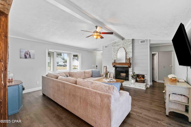 living room featuring dark wood-type flooring, a fireplace, and a textured ceiling