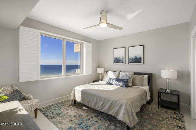 bedroom with a water view and ceiling fan