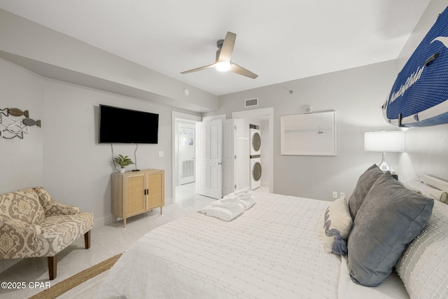 bedroom with ceiling fan and stacked washing maching and dryer