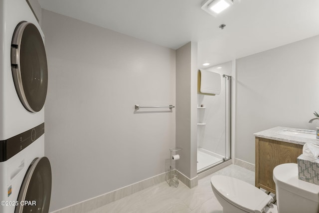 bathroom featuring stacked washer / dryer, toilet, an enclosed shower, and vanity