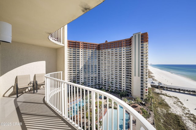 balcony featuring a water view and a beach view