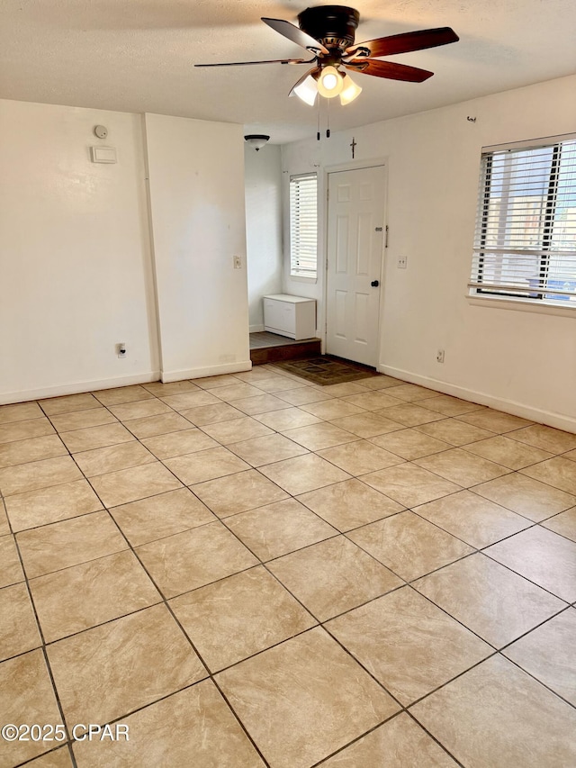 empty room featuring ceiling fan and light tile patterned flooring