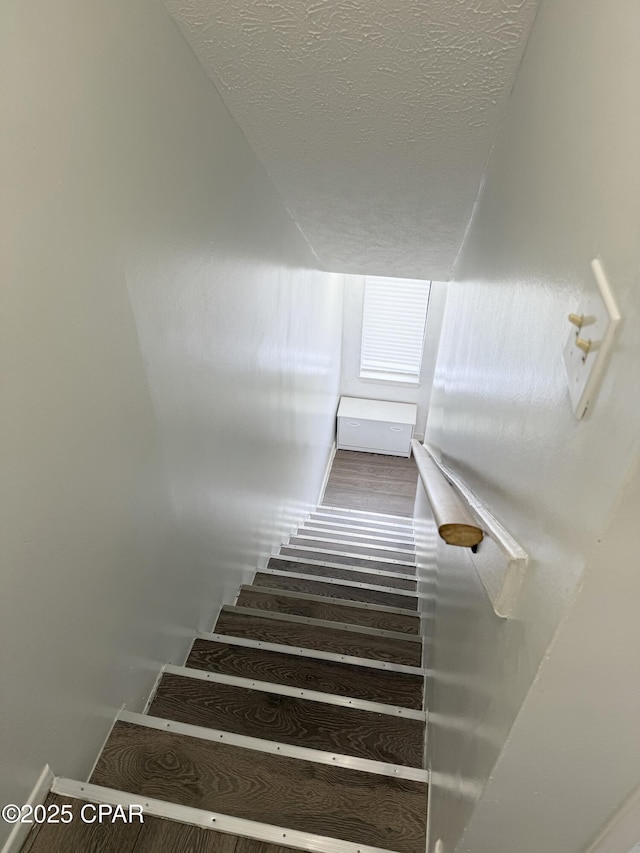 stairway with a textured ceiling