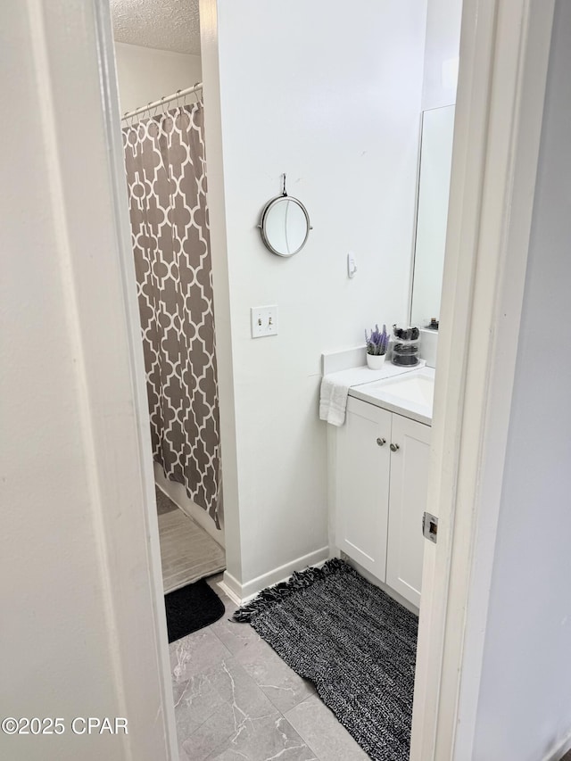 bathroom with a textured ceiling and vanity