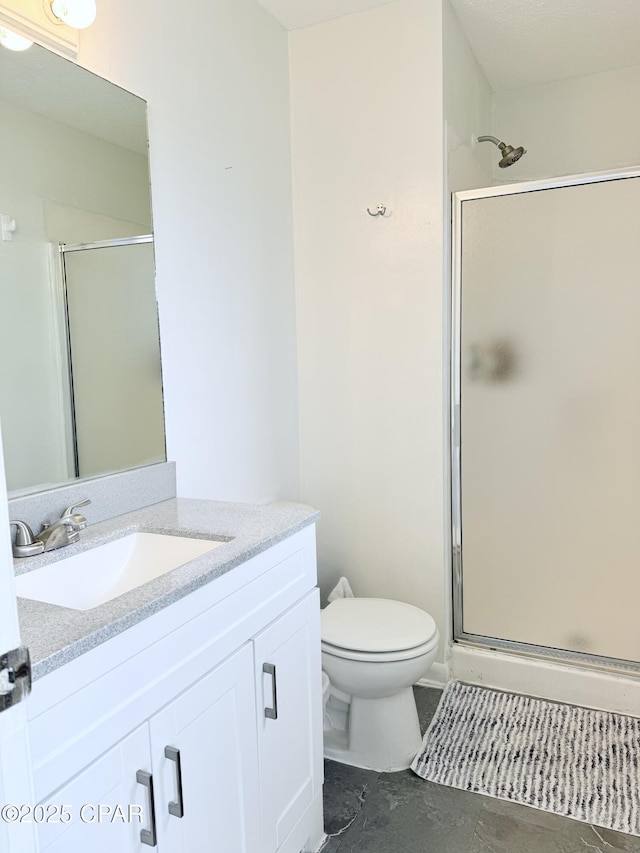 bathroom with toilet, a shower with shower door, and vanity