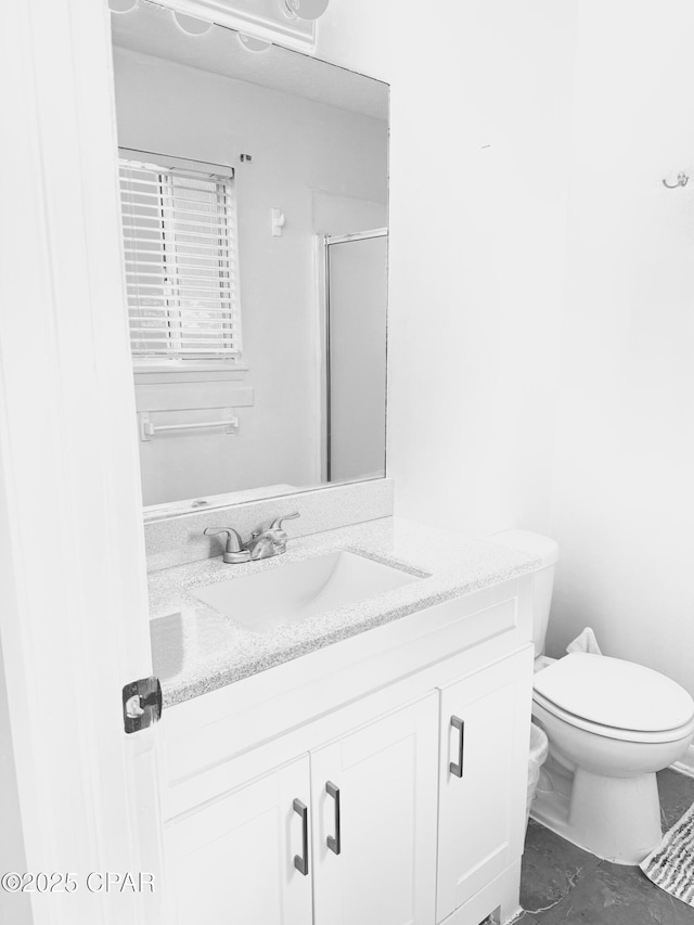 bathroom featuring an enclosed shower, vanity, and toilet