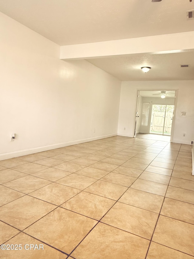 tiled empty room featuring ceiling fan