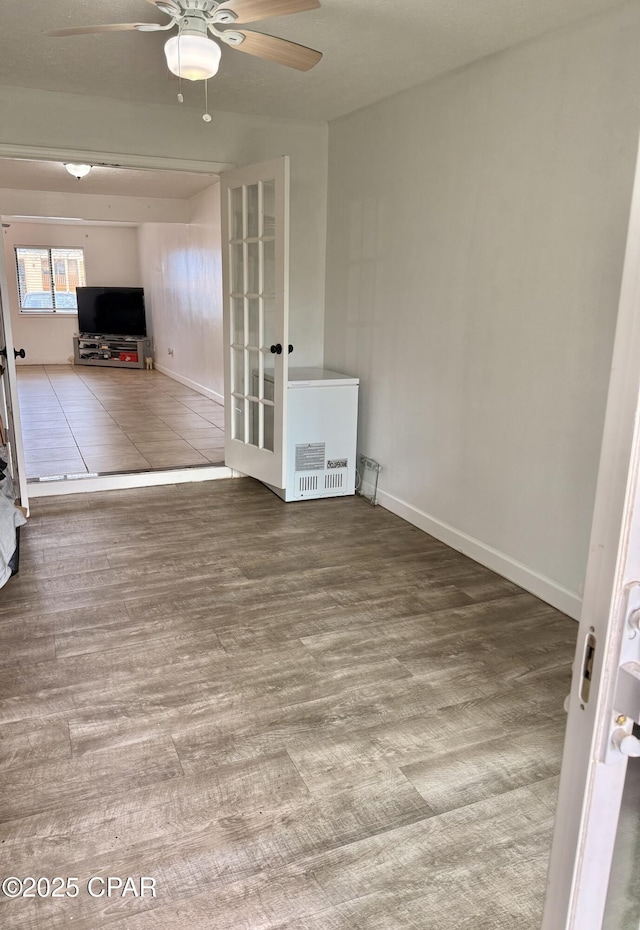 unfurnished living room with wood-type flooring and ceiling fan