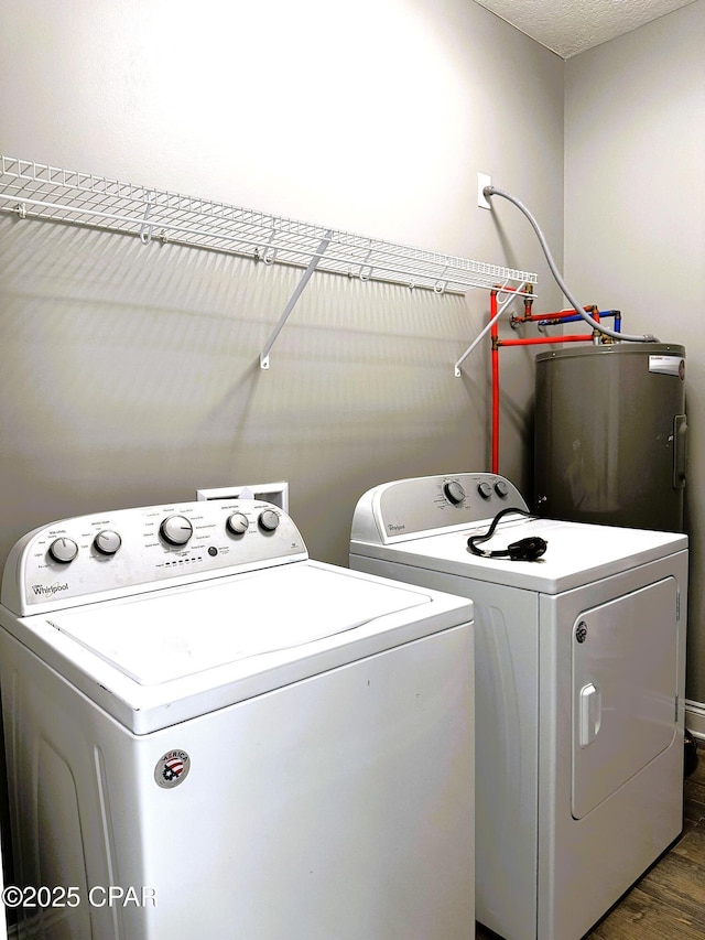 washroom with dark hardwood / wood-style flooring, electric water heater, and washer and dryer