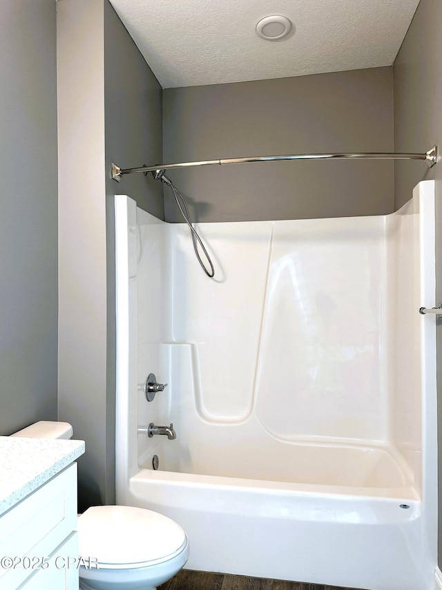 full bathroom featuring vanity, toilet, shower / bath combination, and a textured ceiling