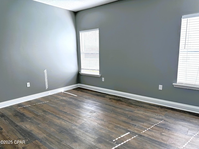 unfurnished room with dark hardwood / wood-style flooring