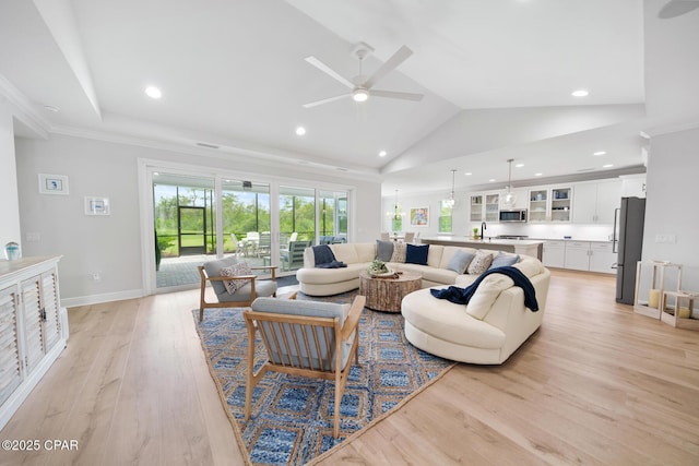 living room featuring high vaulted ceiling, sink, ornamental molding, ceiling fan, and light wood-type flooring