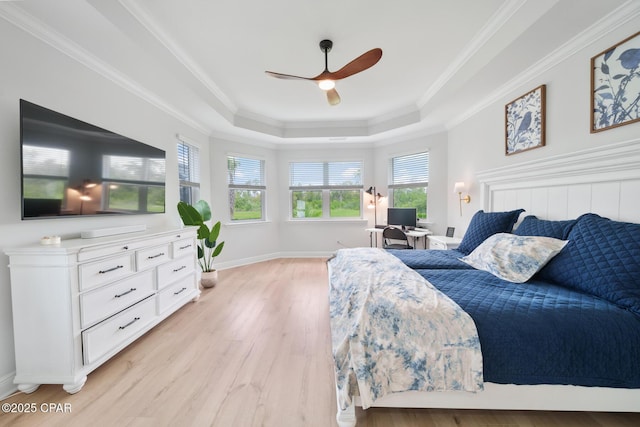 bedroom with multiple windows, a tray ceiling, ornamental molding, and ceiling fan