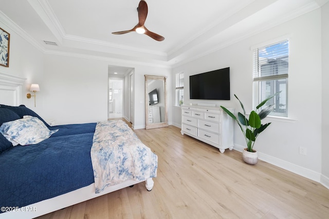 bedroom with multiple windows, a tray ceiling, crown molding, and ceiling fan