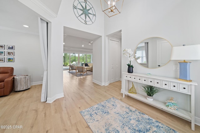 entrance foyer with hardwood / wood-style flooring, ceiling fan with notable chandelier, and ornamental molding