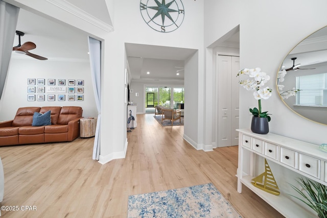 foyer featuring ceiling fan, ornamental molding, and light hardwood / wood-style flooring