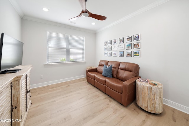 living room featuring ornamental molding, ceiling fan, and light wood-type flooring