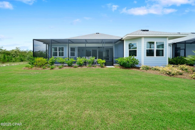 rear view of house featuring glass enclosure and a lawn