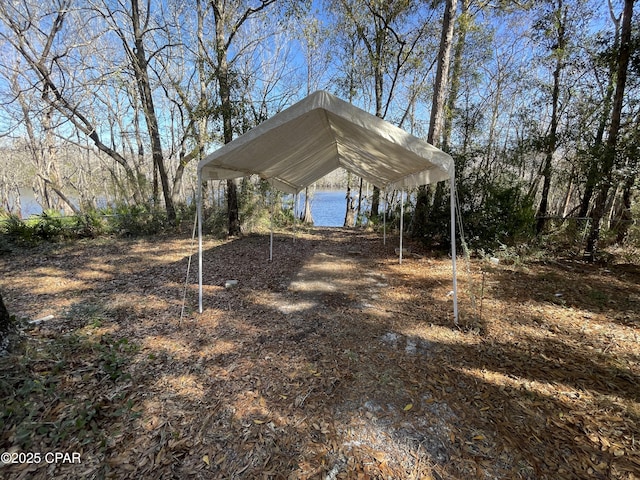 view of parking featuring a water view and a carport